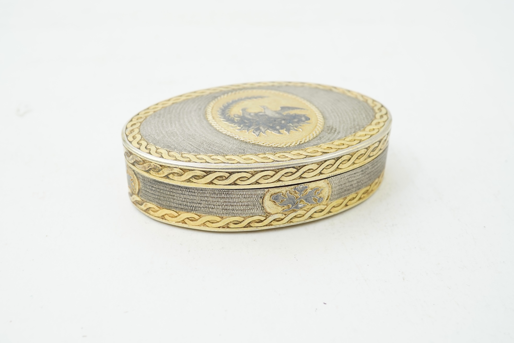 A 19th century Swiss? parcel gilt white metal oval snuff box with hinged cover